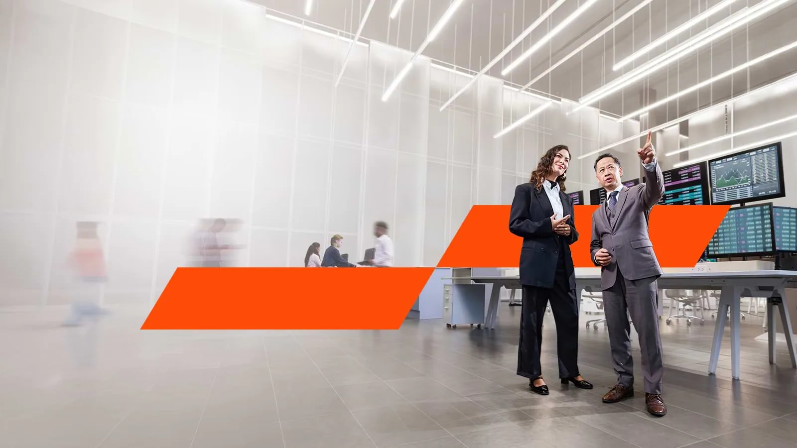 Two people talking in an office space with the PwC logo behind them